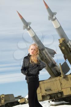 brutal girl standing on a background of military ballistic missiles