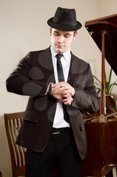 a young man standing near piano in suit