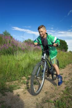 young boy with a bicycle in nature rests. summer vacation