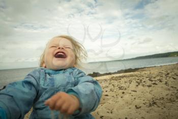 little girl laughing on the beach . summer vacation by the ocean