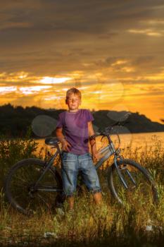 boy on a bicycle near the sea in the evening at sunset. summer vacation