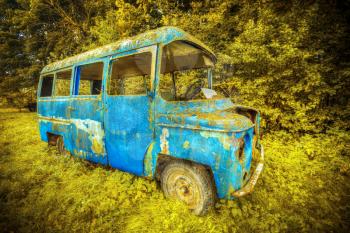 rusty old blue bus standing in the woods