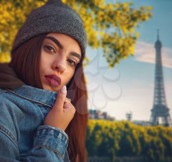 girl against the backdrop of the eiffel tower in Paris in the fall.