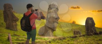 A male tourist is photographing statues on Easter Island.