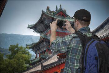 blogger shoots video on the smartphone Shaolin Temple.