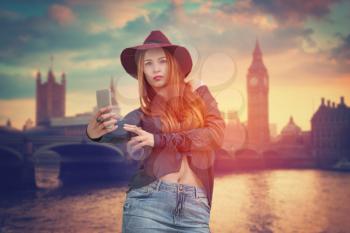 Girl making selfie on the background of Big Ben, London, England