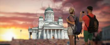 couple of travelers make a photo on a smartphone in the background of Helsinki, Finland