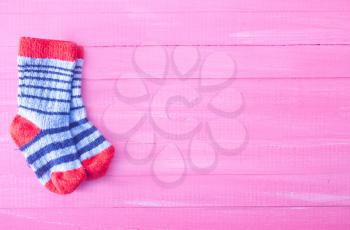 baby socks on the pink wooden table