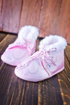 baby shoes on the wooden table, pink shoes