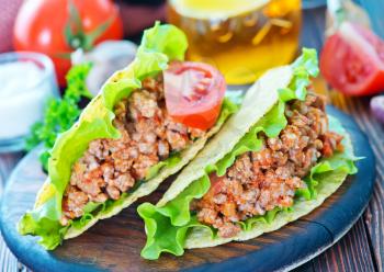 taco with meat and tomato on a table
