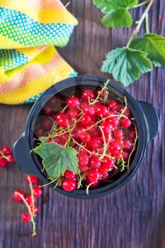 red currant in black bowl and on a table