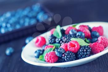 berries on white plate and on a table