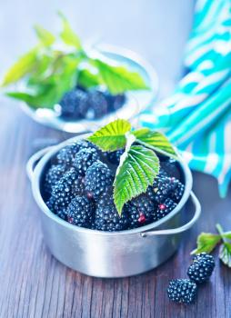 fresh blackberry in metal bowl and on a table