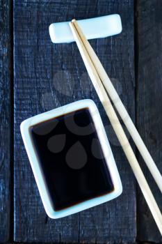 soy sauce and bamboo sticks on a table