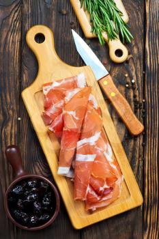 Slices of tasty spanish ham on board 