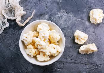 raw cauliflower on plate and on a table