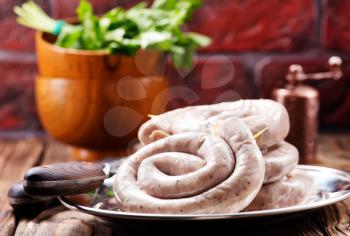 raw sausages with salt and spice on a table