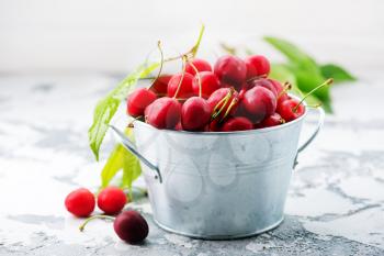 fresh cherry in metal bowl and on a table