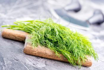 fresh dill on board and on a table