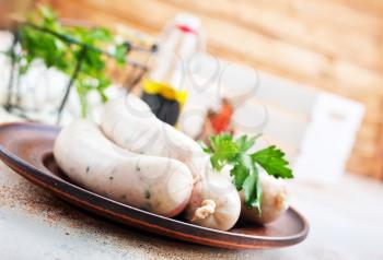 white sausages on plate and on a table