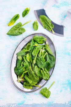 fresh spinach on metal plate on a table