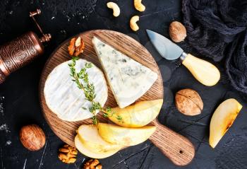cheese with nuts and honey on wooden board