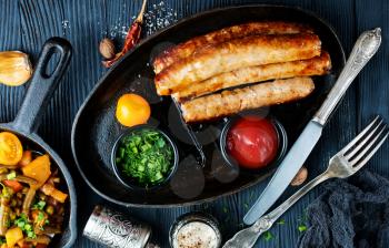 fried sausages with tomato sauce on black plate