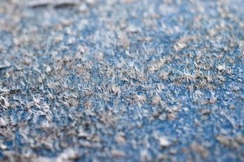 White hoarfrost crystals on flat surface closeup macro view with selective focus, shallow depth of field.