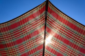 Sun rays through the fabric of the umbrella against the blue sky