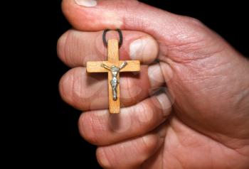 Hand with a cross on a dark background