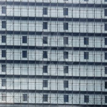 Close-up fragment of the facade of a modern building with large glass windows. Modern architecture. Modern industrial building with glass. Exterior of a multistory building.
