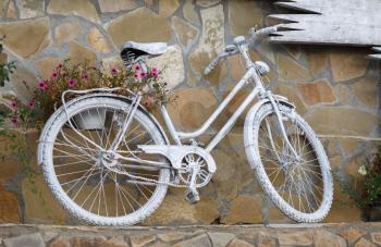 Bike, painted with white paint, standing against the wall.
