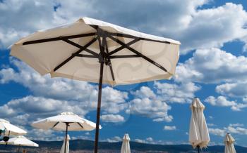 White beach umbrellas on a background of sea and sky. Shallow depth of field.