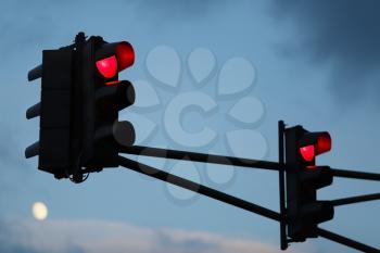 Traffic light with red light against the evening sky. Shallow depth of field. Selective focus.