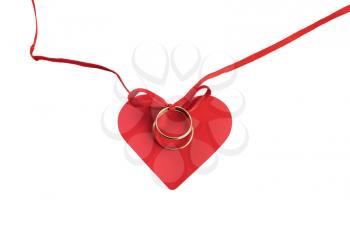 Golden rings on a red ribbon with a bow on a background of red heart. Isolated on white background.