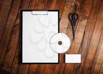 Blank stationery set. Blank paper, clipboard, business card, cd and scissors on vintage wooden table background. Blank corporate identity template. Mock-up for branding identity. Top view.