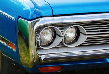 Headlights of blue retro car. Retro styled blue classic car. Selective focus.