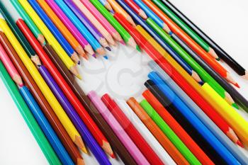 Bright colored pencils laid out in a heart shape. Pencils lying on a flat surface.