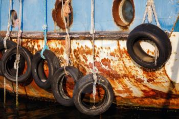 Nesebar, Bulgaria - September 10, 2014: Old tires on ship. Used for impact protection of a ship. Old ship in the port of the old town of Nessebar, Bulgaria. Selective focus.