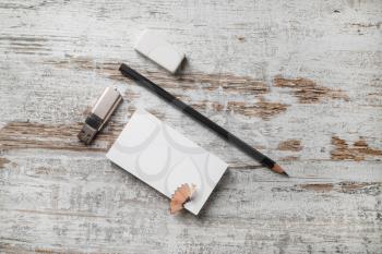 Photo of blank stationery. Bank business card, pencil, eraser and flash drive on vintage wooden table background. Top view.