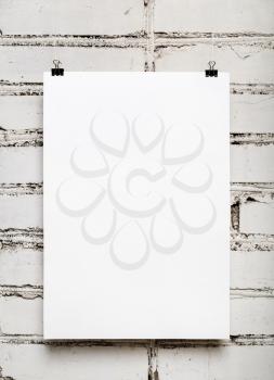 Blank wall calendar with spring on white brick wall background. Template for design calendars and photo albums. Vertical shot.