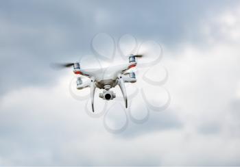 Quadrocopter drone hovers in the sky. Drone quad copter. Flying unmanned camera.