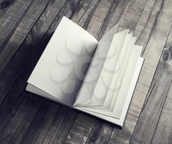 Open book, brochure or notebook with blank pages on wood table background. Vintage toned image.