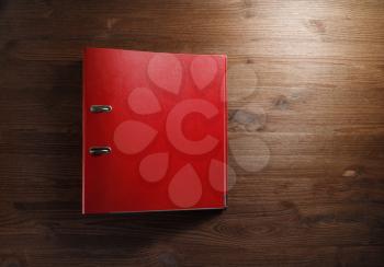 Red office folder on wood table background. Blank file folder binder with copy space. Flat lay.