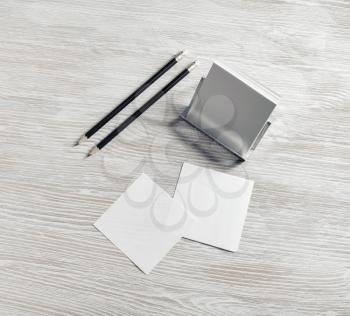 Blank stationery on light wood table background. Notes and pencils.