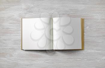 Blank book mock up on light wooden background. Flat lay.
