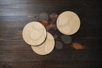 Blank cork beer coasters on wood table background. Flat lay.