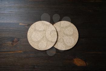 Photo of two blank cork beer coasters on wooden background. Flat lay.