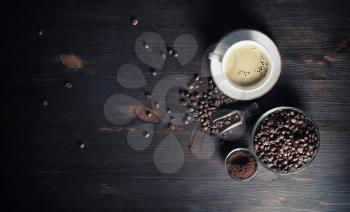 Vintage coffee background. Coffee cup, coffee beans and ground powder on wood kitchen table.. Copy space for your text. Flat lay.
