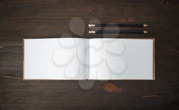Blank sketchbook and pencils mock up on wooden background. Template for placing your design. Flat lay.
